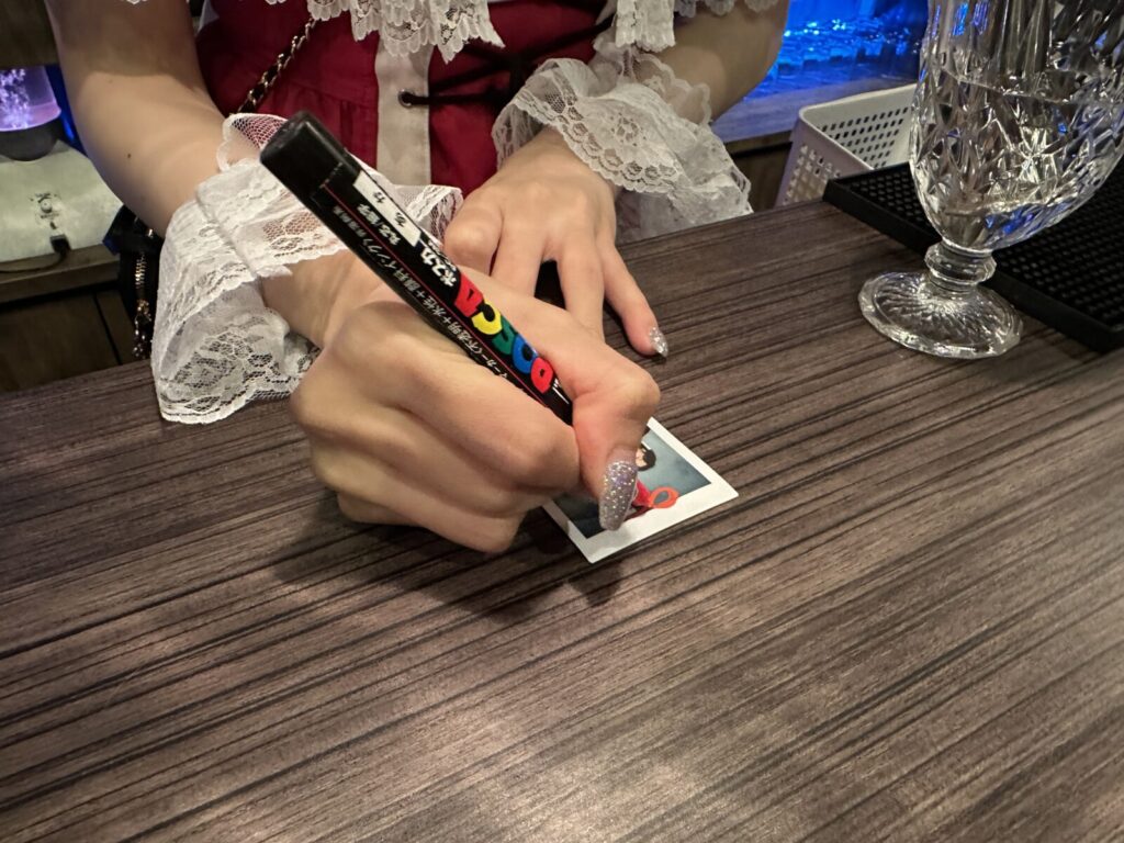 チェキに落書きをする手元