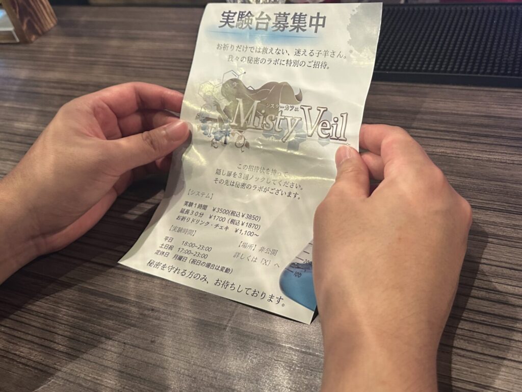 チラシを持ちテーブルに手をついている