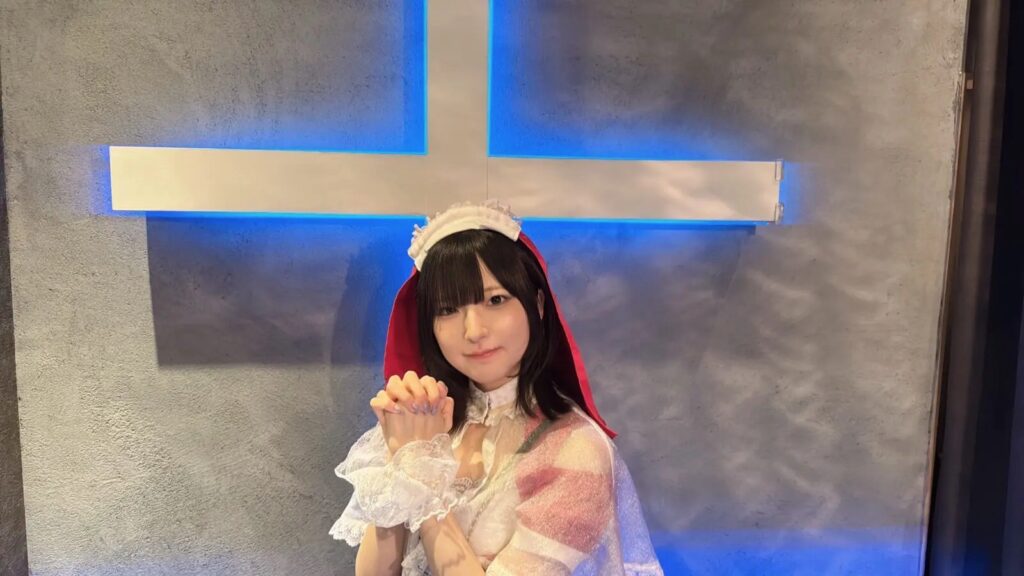 十字架の前で祈り手を組むえまさん